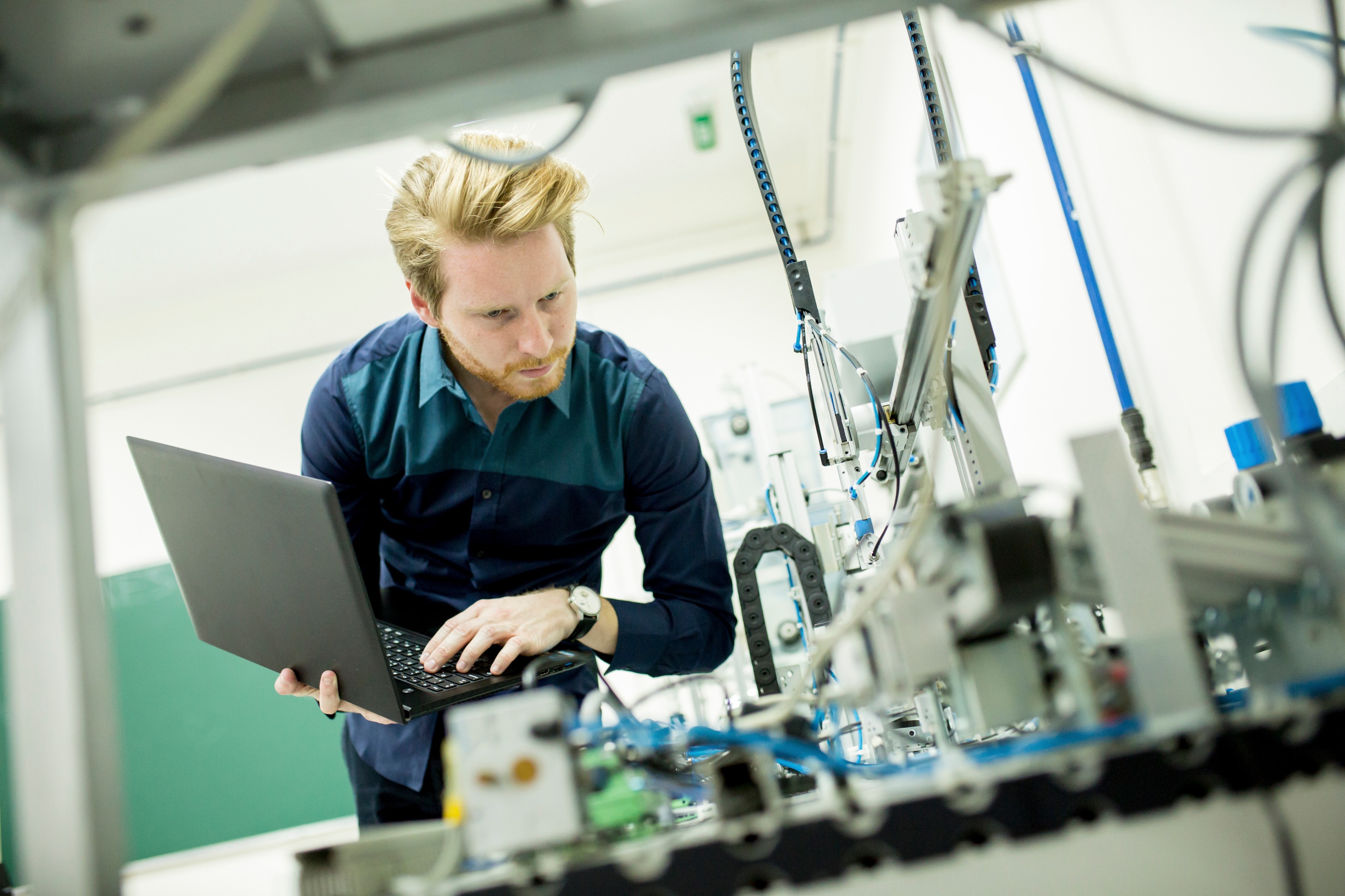 Engineer | Engineering Recruitment | Engineer works on electrical equipment in a factory