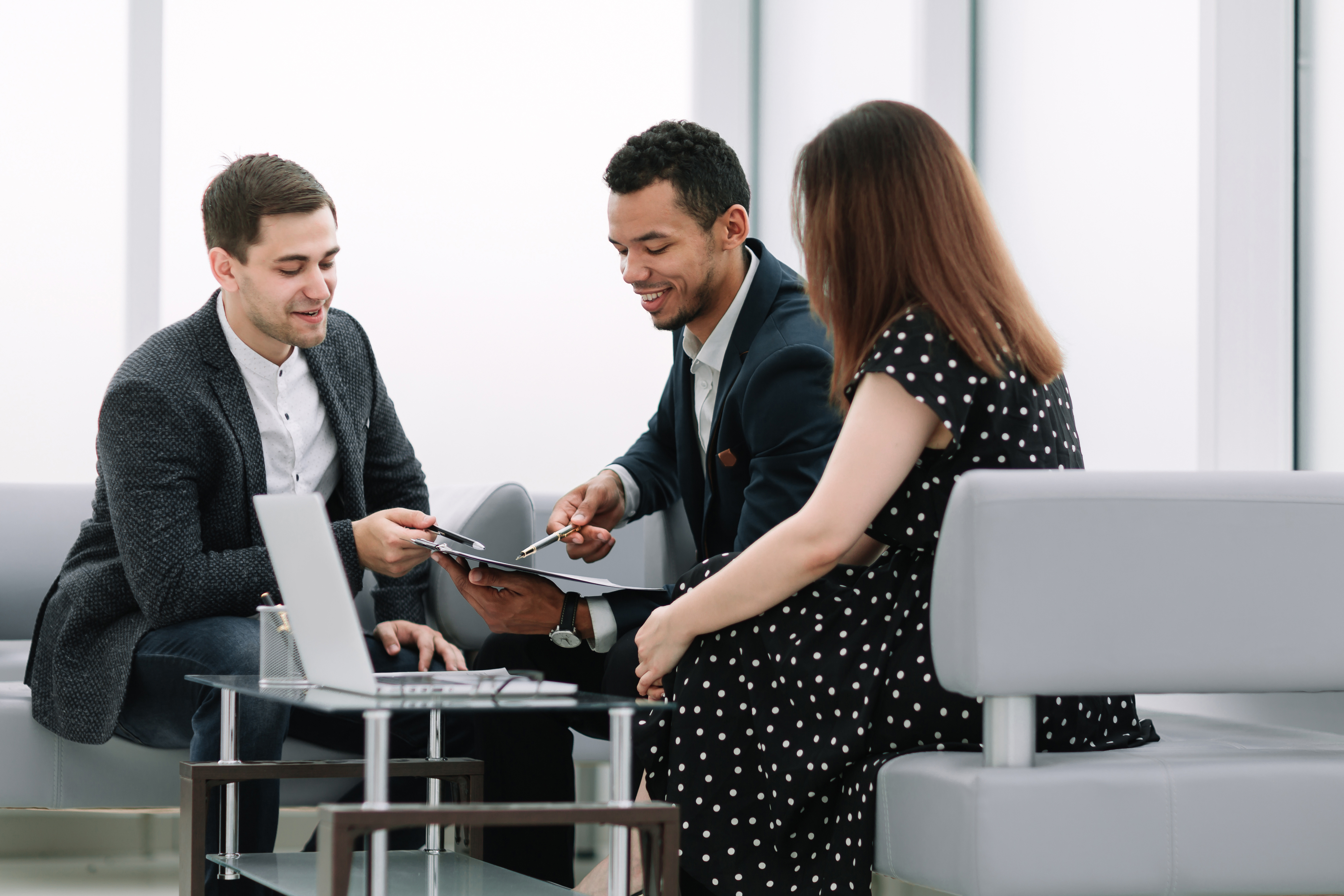Team of financial professionals discussing company numbers around a small table | Yolk Recruitment